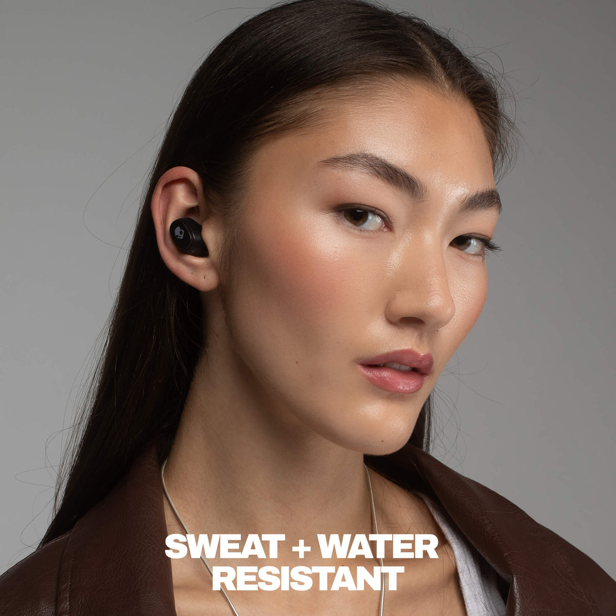 Woman wearing a sweat and water-resistant electronic device with a neutral background | True Black