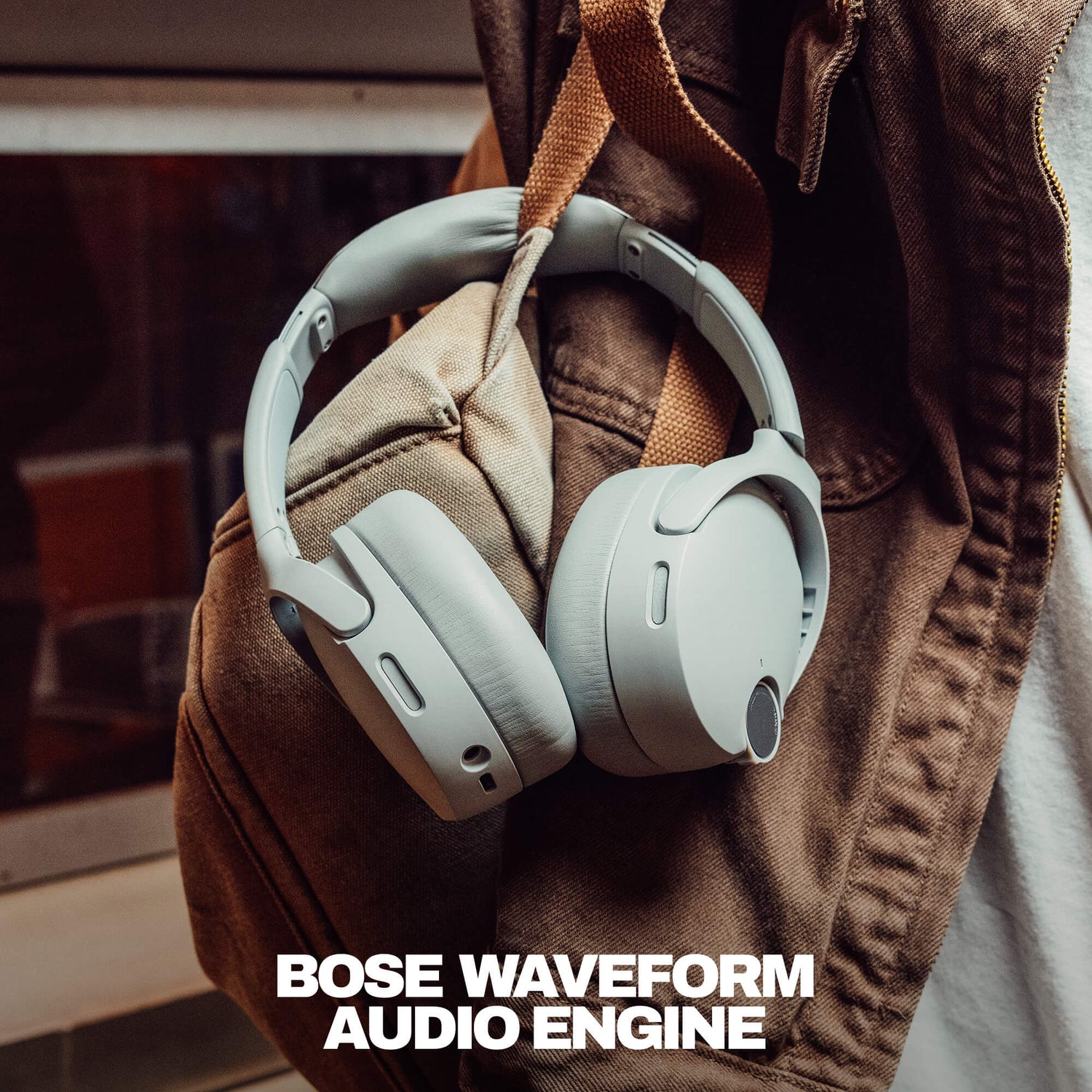 Skullcandy headphones on a brown jacket with 'Bose Waveform Audio Engine' text. | Cement