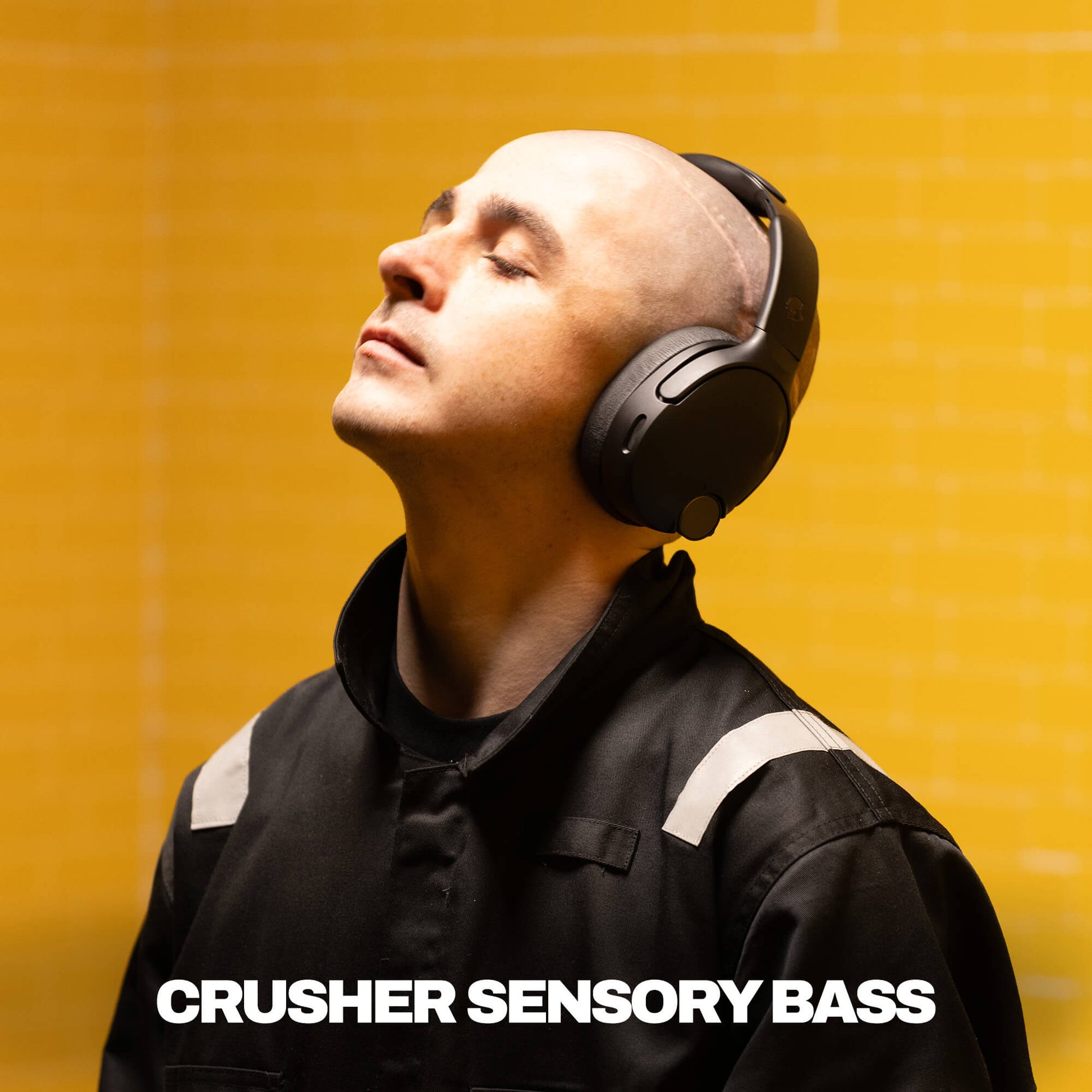 Man wearing headphones with 'Crusher Sensory Bass' text on a yellow background | True Black