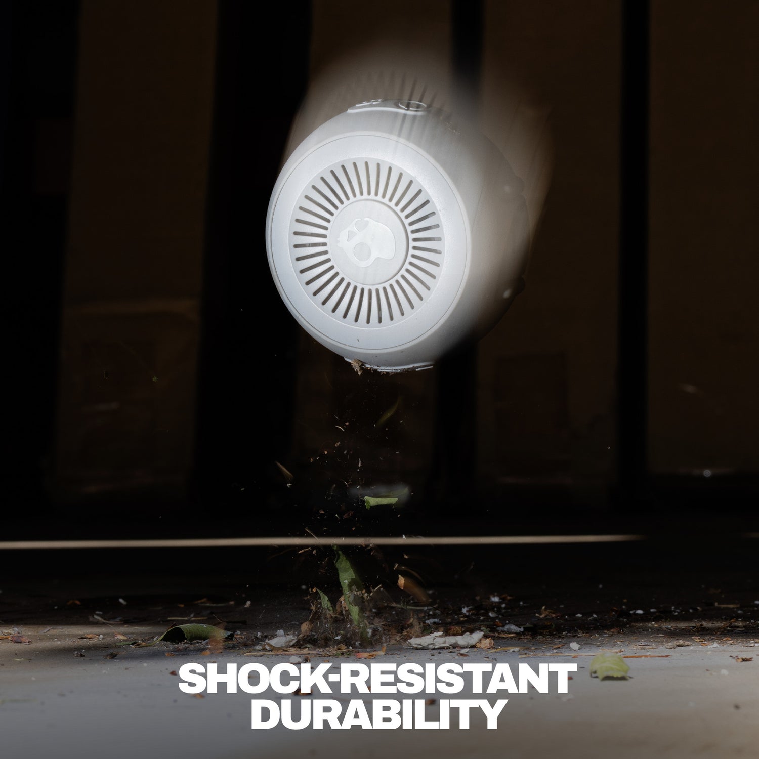 Speaker being dropped onto a concrete surface with text 'SHOCK-RESISTANT DURABILITY' below. | Cement