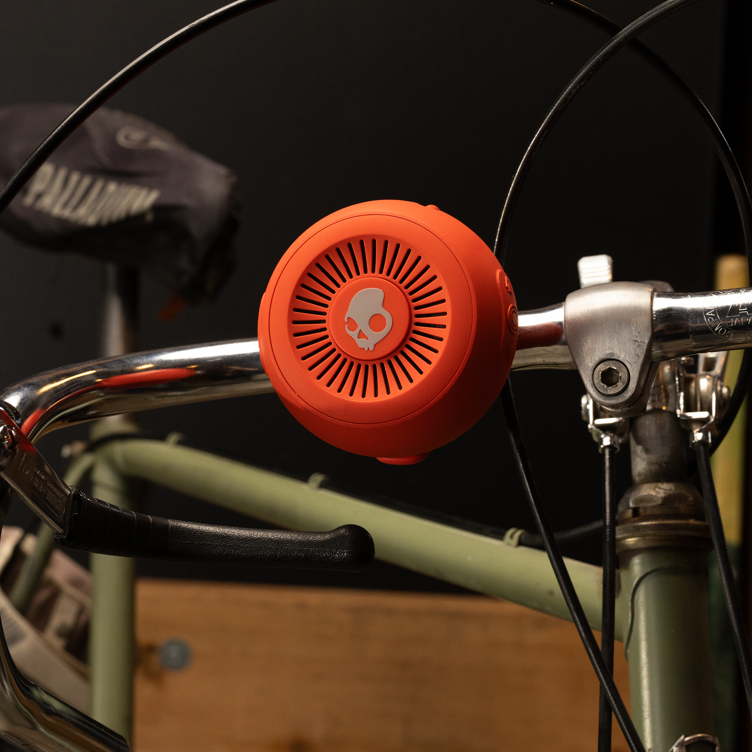 Orange speaker attached to a bike handlebar with a blurred background | Plasma