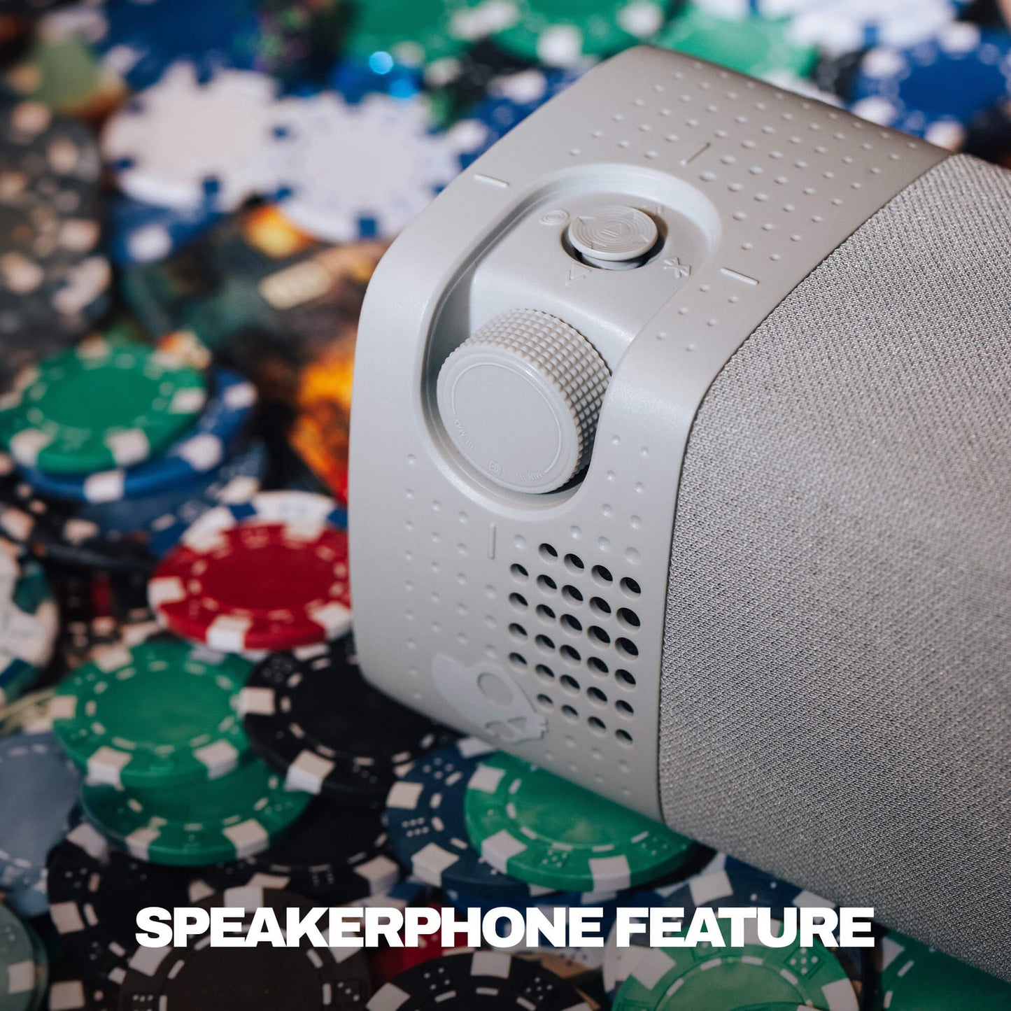 A close-up of a white and gray session 900 with a textured fabric cover, resting on a pile of colorful poker chips. The text 'SPEAKERPHONE FEATURE' is overlaid at the bottom. | Cement