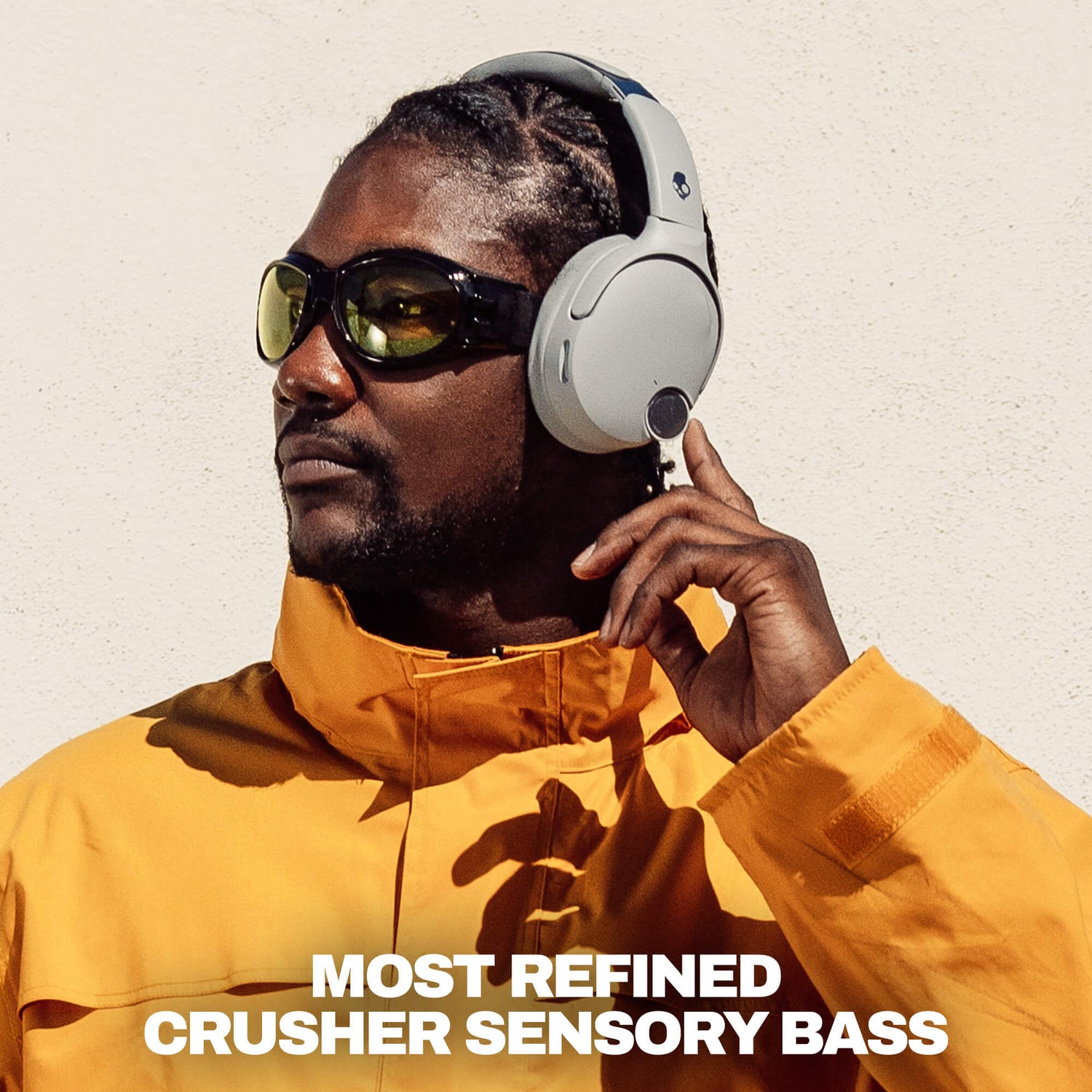 A man wearing white over-ear headphones and dark sunglasses, dressed in a bright yellow jacket, with the text 'MOST REFINED CRUSHER SENSORY BASS' at the bottom. | Cement