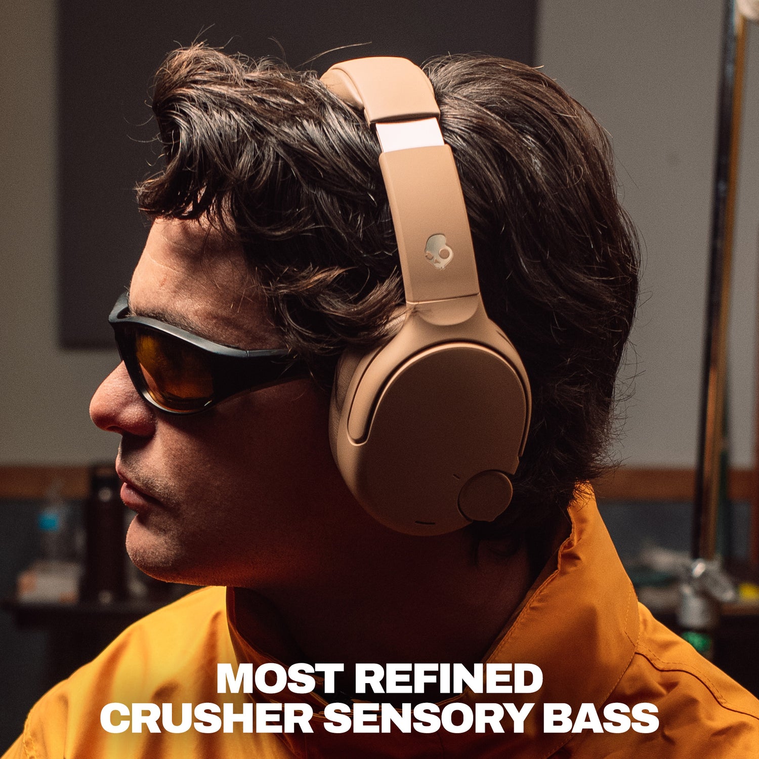 A man in profile wearing tan over-ear headphones and dark sunglasses, with bold text at the bottom reading 'MOST REFINED CRUSHER SENSORY BASS'. | Primer