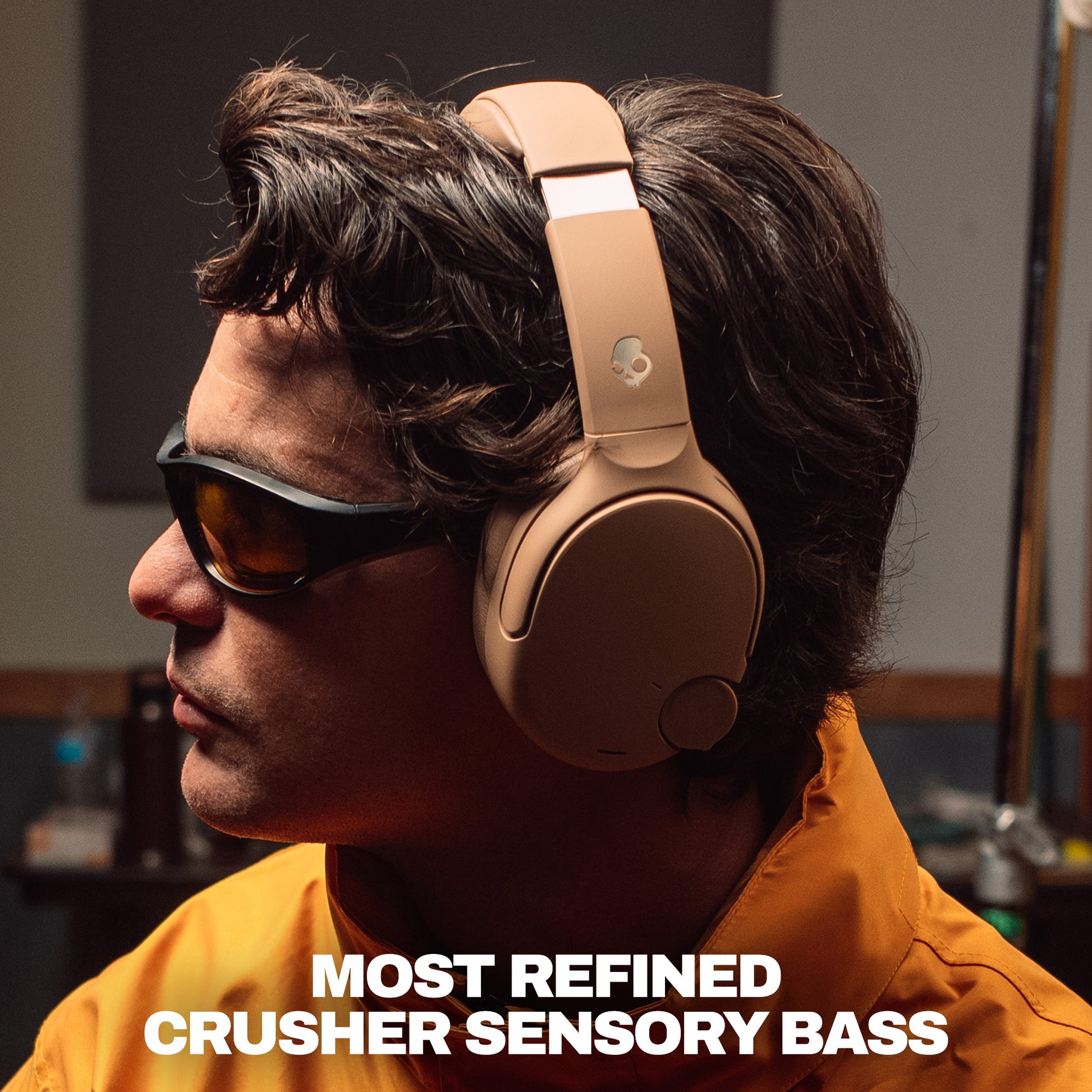 A man in profile wearing tan over-ear headphones and dark sunglasses, with bold text at the bottom reading 'MOST REFINED CRUSHER SENSORY BASS'. | Primer